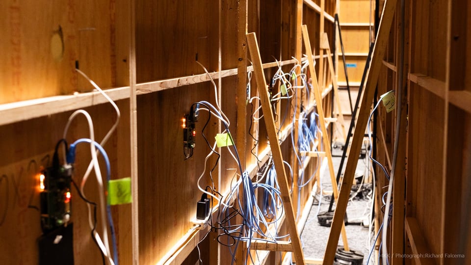 Custom electronics, network cabling, and control hardware installed behind the exhibition walls